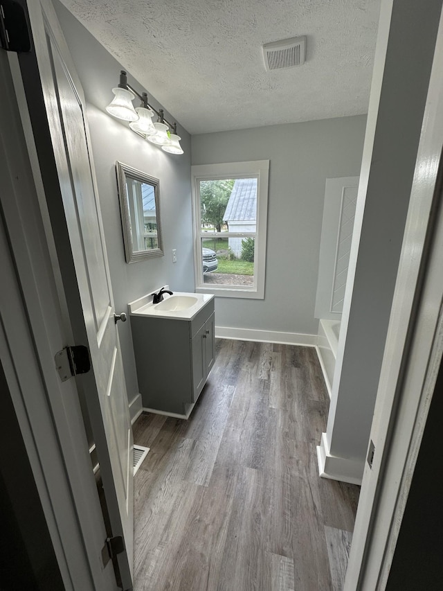 105 Murfreesboro St, Murfreesboro, TN 37127 - full bath with a textured ceiling, vanity, wood finished floors, a tub, and baseboards
