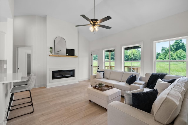 178 Dewberry Ct, Clarksville, TN 37042 - living room featuring high vaulted ceiling, light wood finished floors, a glass covered fireplace, ceiling fan, and baseboards