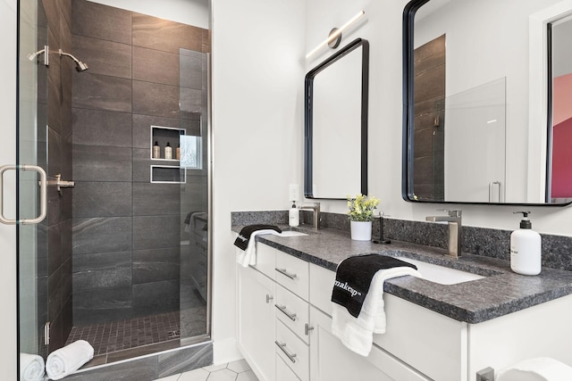 full bathroom featuring a shower stall and double vanity