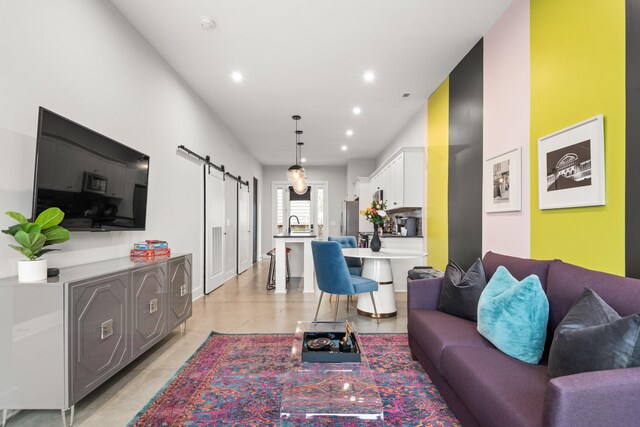 living room featuring a barn door, light tile patterned flooring, and recessed lighting