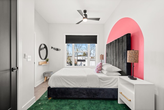 bedroom with ceiling fan and baseboards