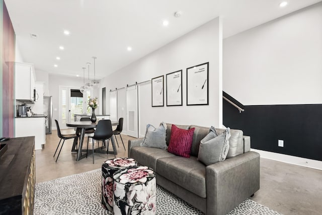 living room with recessed lighting, concrete flooring, and baseboards