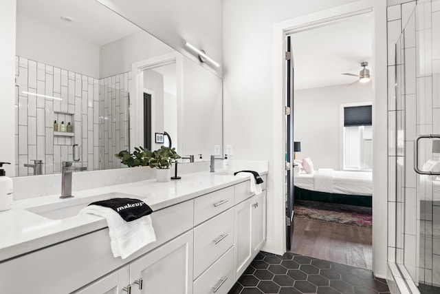 bathroom featuring a ceiling fan, connected bathroom, a shower stall, tile patterned flooring, and double vanity