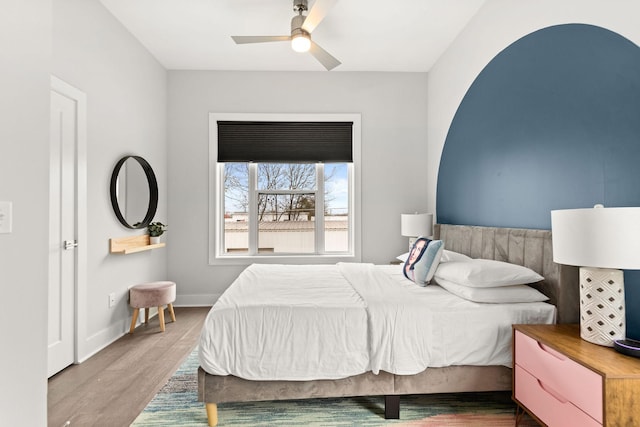 bedroom with wood finished floors, baseboards, and ceiling fan