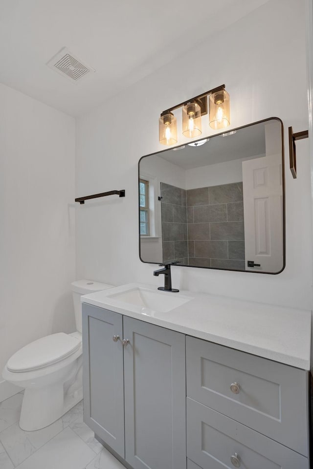 bathroom featuring marble look tiles, vanity, toilet, and a shower