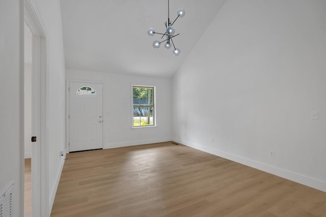 entryway with a chandelier, high vaulted ceiling, baseboards, and light wood finished floors
