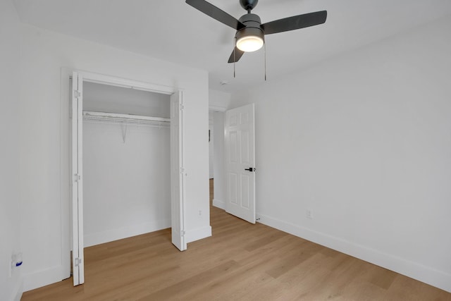 unfurnished bedroom featuring light wood-style floors, baseboards, a closet, and a ceiling fan