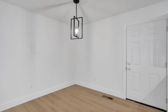 unfurnished dining area with light wood-style flooring and baseboards