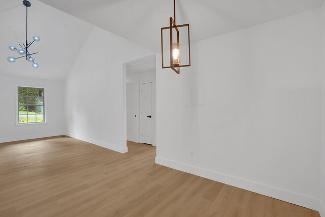 unfurnished dining area with a chandelier, light wood-style floors, vaulted ceiling, and baseboards