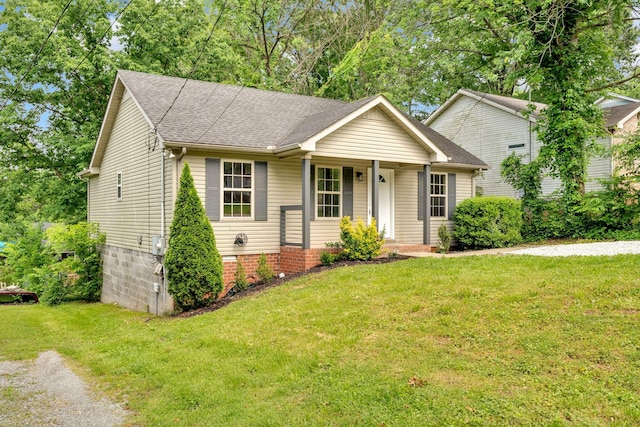 view of front of house with a front yard and a shingled roof