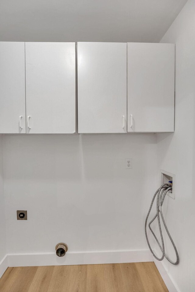 washroom featuring cabinet space, hookup for a washing machine, hookup for an electric dryer, light wood-style floors, and baseboards
