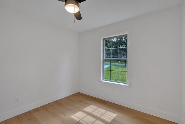 unfurnished room featuring baseboards, healthy amount of natural light, and light wood finished floors