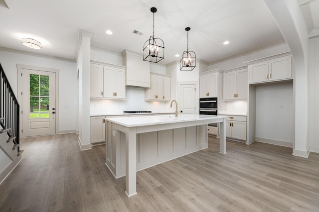 508 Gresham Ln, Murfreesboro, TN 37129 - kitchen featuring light countertops, black appliances, a sink, light wood-type flooring, and hanging light fixtures