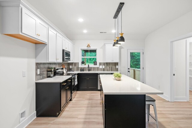 182 Dewberry Ct, Clarksville, TN 37042 - kitchen with appliances with stainless steel finishes, dark cabinets, a sink, a kitchen island, and backsplash