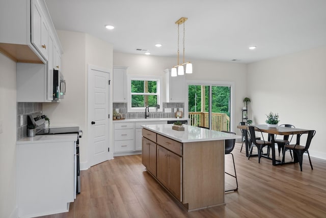 186 Dewberry Ct, Clarksville, TN 37042 - kitchen with appliances with stainless steel finishes, tasteful backsplash, a kitchen bar, a sink, and light wood-type flooring