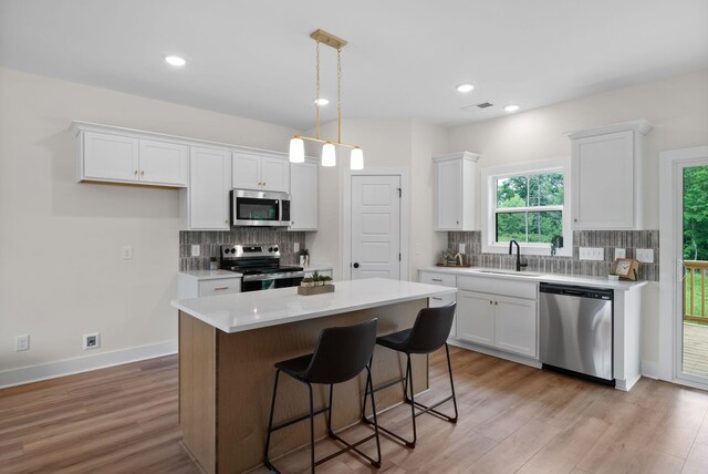 186 Dewberry Ct, Clarksville, TN 37042 - kitchen with appliances with stainless steel finishes, a sink, white cabinets, tasteful backsplash, and recessed lighting