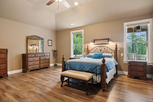 bedroom featuring wood finished floors, baseboards, vaulted ceiling, and a ceiling fan