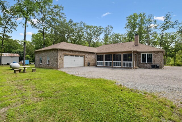 single story home featuring driveway, a garage, brick siding, and a chimney