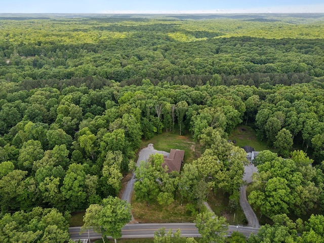 aerial view of property and surrounding area featuring a heavily wooded area