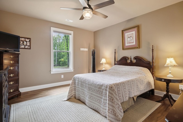 bedroom featuring baseboards, wood finished floors, and ceiling fan