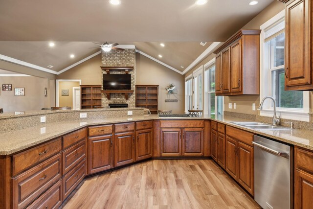 kitchen featuring dishwasher, a sink, a ceiling fan, light wood-style floors, and vaulted ceiling