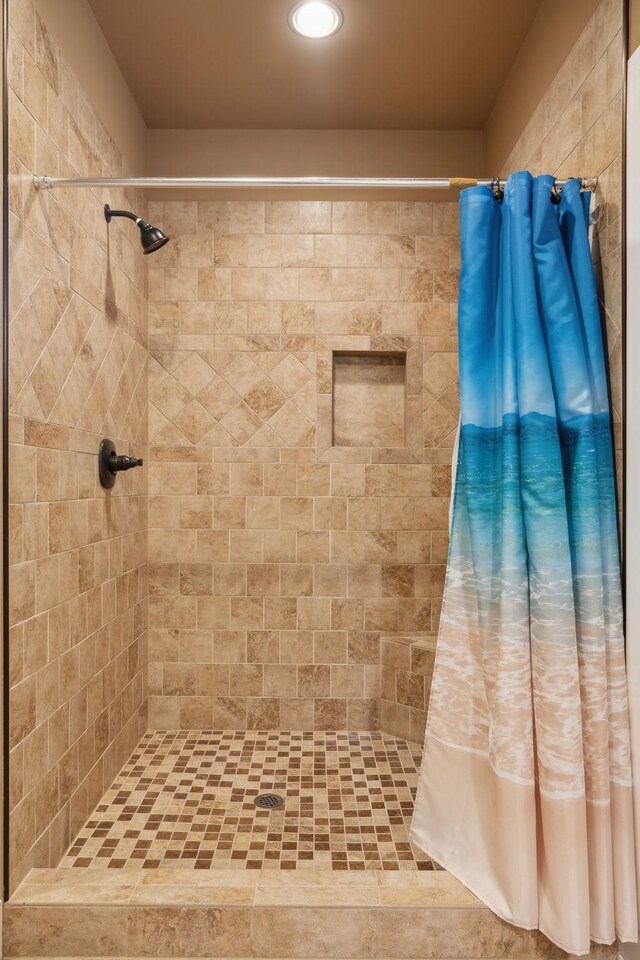 bathroom with tiled shower and recessed lighting
