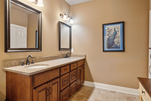 bathroom with baseboards and double vanity