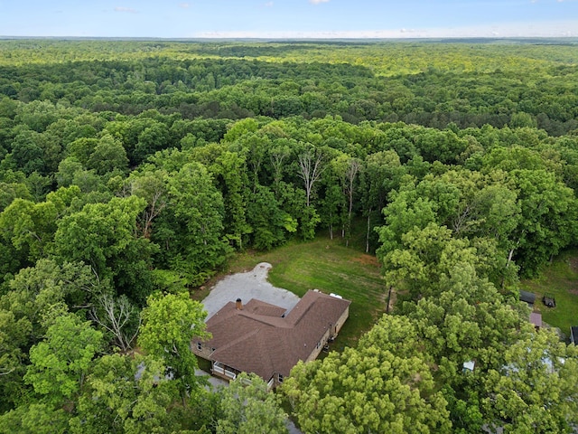 aerial view of property and surrounding area featuring a heavily wooded area