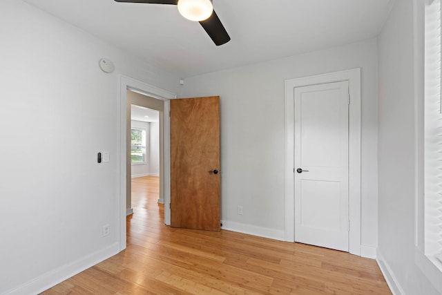 unfurnished bedroom with light wood-type flooring, baseboards, and ceiling fan