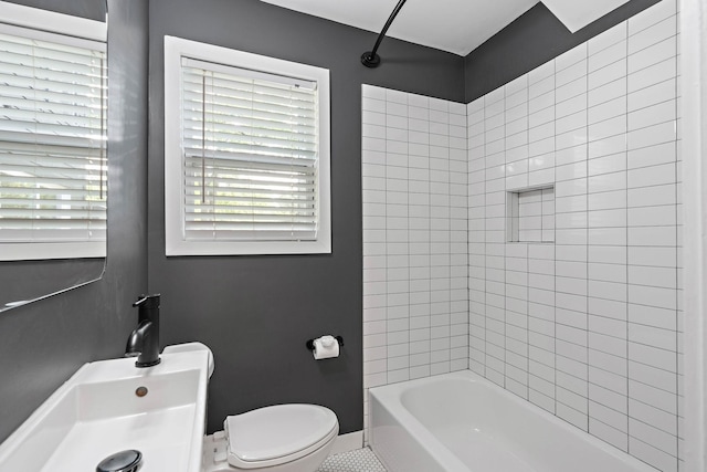 bathroom with toilet, shower / bathtub combination, and baseboards