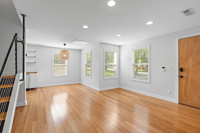 unfurnished living room with recessed lighting, baseboards, plenty of natural light, and light wood-style flooring