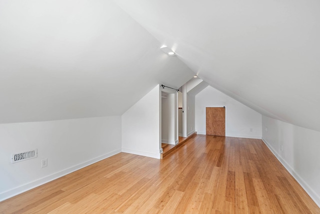 bonus room with lofted ceiling, light wood-style flooring, and baseboards