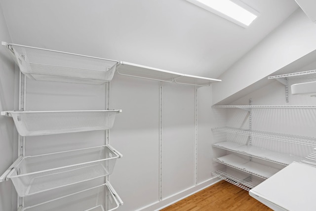 walk in closet with wood finished floors