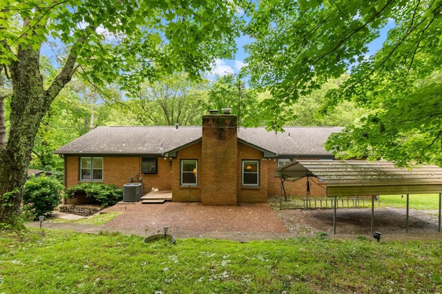 1326 Holly Tree Gap Rd, Brentwood, TN 37027 - rear view of house with cooling unit, a chimney, a patio area, roof with shingles, and brick siding