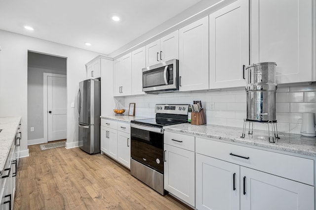 2617 Leawood Ct, Murfreesboro, TN 37128 - kitchen with stainless steel appliances, decorative backsplash, baseboards, white cabinets, and light wood-style flooring