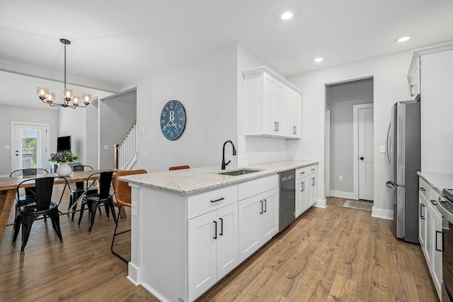 2617 Leawood Ct, Murfreesboro, TN 37128 - kitchen with stainless steel appliances, a sink, a peninsula, white cabinets, and wood finished floors