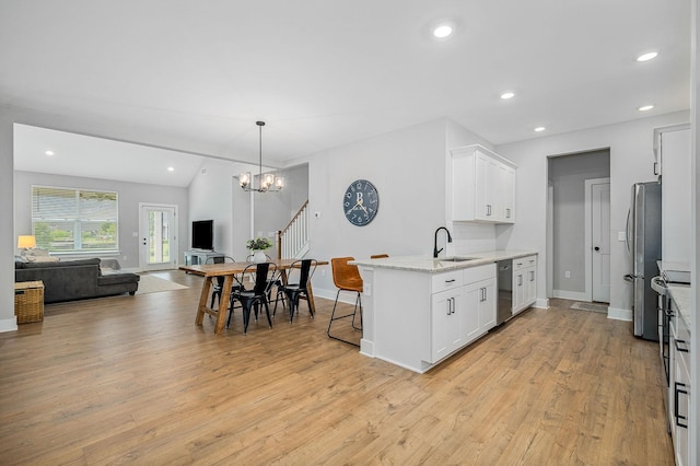 2617 Leawood Ct, Murfreesboro, TN 37128 - kitchen with appliances with stainless steel finishes, open floor plan, white cabinets, light wood-style flooring, and a sink