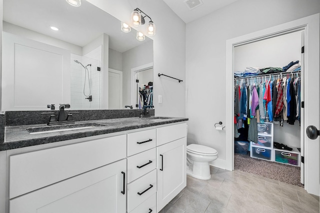 2617 Leawood Ct, Murfreesboro, TN 37128 - full bathroom featuring a tile shower, a walk in closet, double vanity, toilet, and tile patterned floors