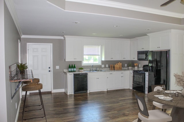 430 Gobble St, Lawrenceburg, TN 38464 - kitchen with black appliances, white cabinetry, dark wood-style floors, ornamental molding, and light stone counters