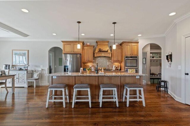 503 Carriage Ln, Lebanon, TN 37087 - kitchen featuring appliances with stainless steel finishes, premium range hood, arched walkways, a center island with sink, and recessed lighting