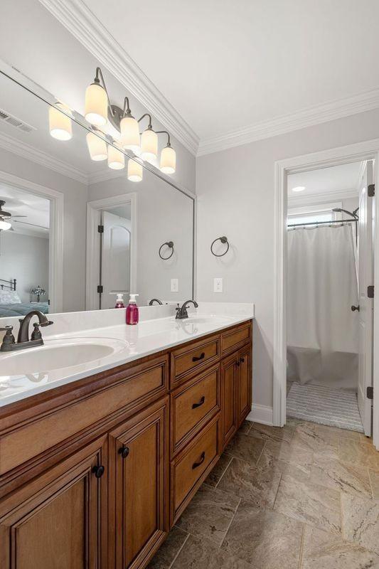 503 Carriage Ln, Lebanon, TN 37087 - bathroom featuring double vanity, crown molding, a shower with shower curtain, and stone finish flooring