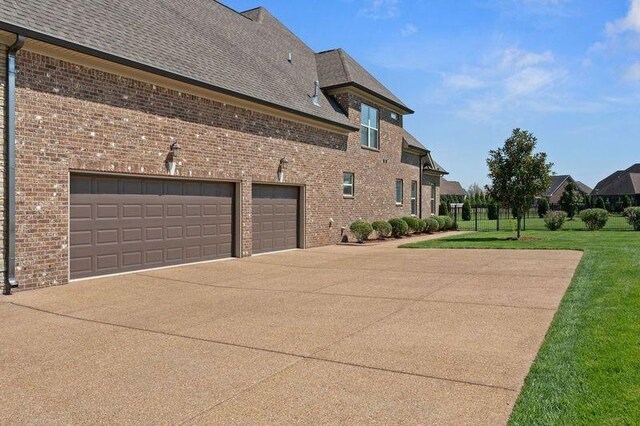503 Carriage Ln, Lebanon, TN 37087 - view of home's exterior with concrete driveway, brick siding, a garage, a yard, and roof with shingles