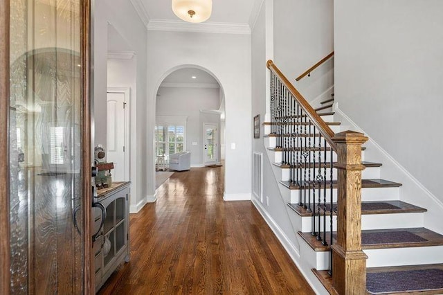 503 Carriage Ln, Lebanon, TN 37087 - foyer entrance featuring arched walkways, dark wood-style flooring, ornamental molding, stairs, and baseboards