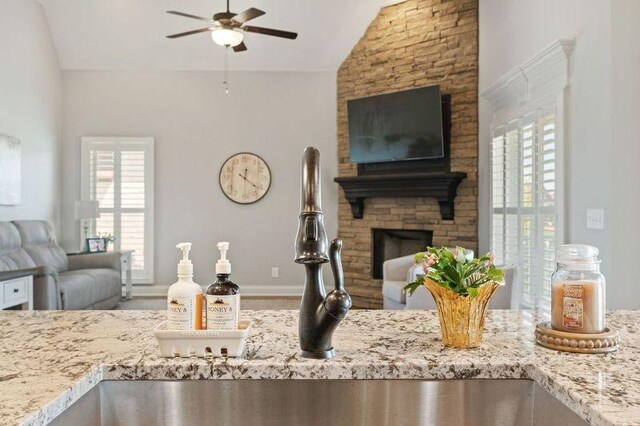 503 Carriage Ln, Lebanon, TN 37087 - kitchen with open floor plan, vaulted ceiling, a ceiling fan, light stone countertops, and a large fireplace