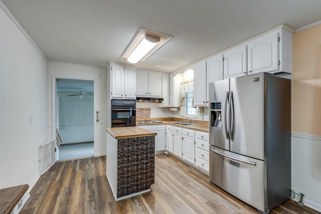 3008 Mcintire Dr, Columbia, TN 38401 - kitchen featuring stainless steel appliances, a sink, white cabinetry, wood finished floors, and ornamental molding