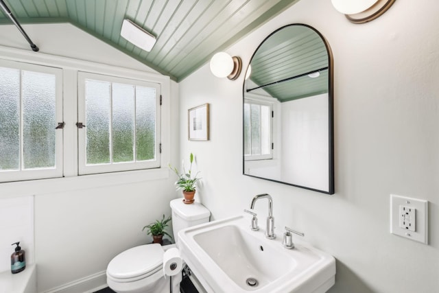 bathroom with lofted ceiling, a sink, healthy amount of natural light, toilet, and wooden ceiling