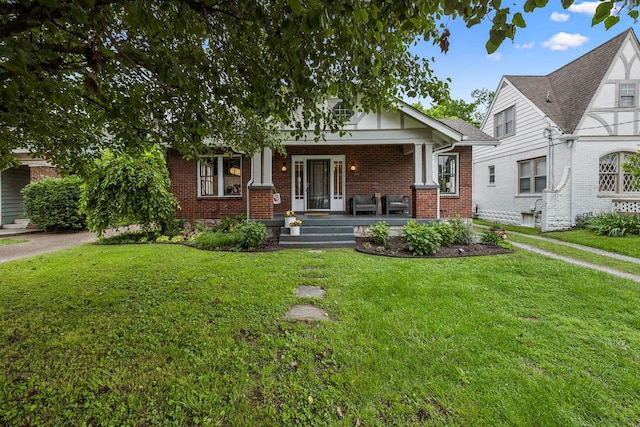 view of front facade featuring a porch, brick siding, and a front lawn