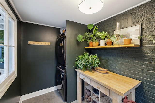 kitchen featuring stacked washer and clothes dryer and baseboards
