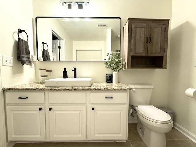 bathroom with tile patterned flooring, toilet, baseboards, and vanity