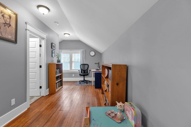 office with lofted ceiling, hardwood / wood-style flooring, and baseboards